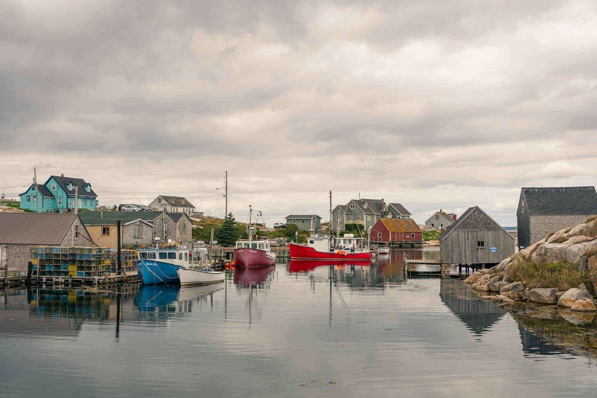 Fishing boats lying in a sheltered harbour among shingled waterfront buildings